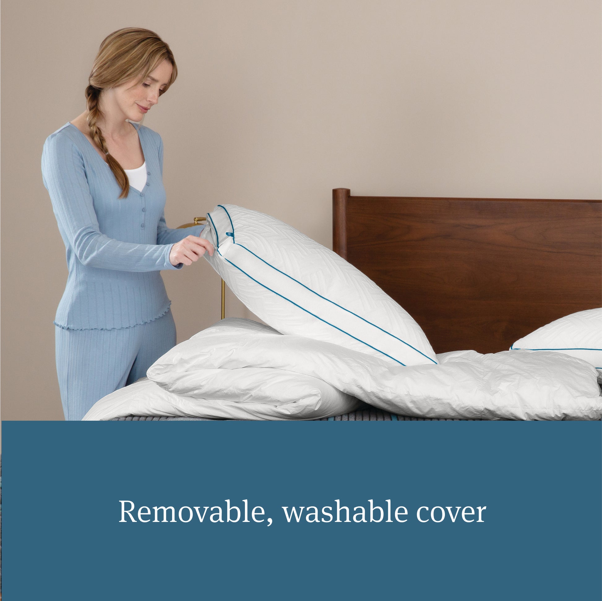 Woman holding a Beautyrest Down Alternative Pillow that is sitting on a down comforter that are both on top of a Beautrest mattress