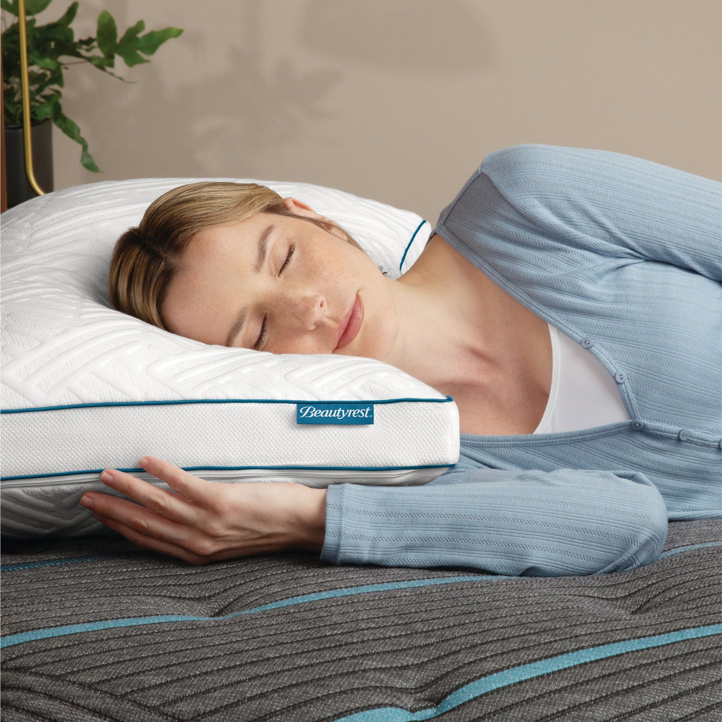 Woman laying on her right side asleep with her head on a Beautyrest Down Alternative Pillow