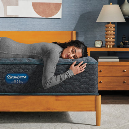 Woman laying on the edge of a Beautyrest mattress asleep