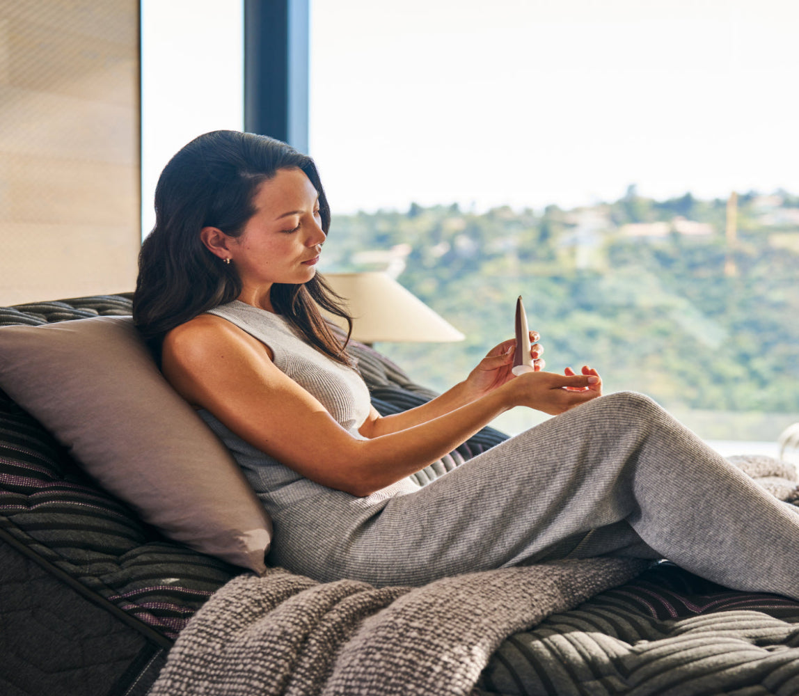 Woman sitting slightly upright on a Beautyrest Black mattress sitting on an adjustable base.