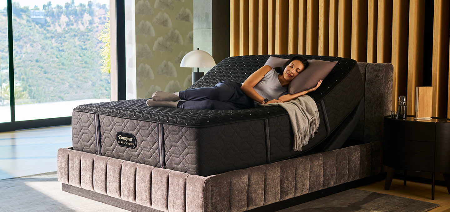 Woman laying on a Beautyrest Hybrid mattress on an adjustable frame slightly elevated at the head